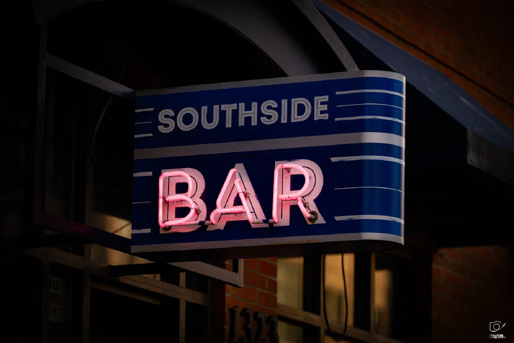 A neon sign displaying SOUTHSIDE BAR is attached to the exterior of a building.
